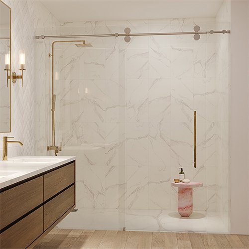 Frameless glass shower enclosure with gold fixtures and white marble tile walls in a modern bathroom with wood vanity.